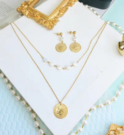 Conjunto de acero inoxidable para dama con dijes en forma de moneda