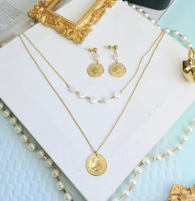 Conjunto de acero inoxidable para dama con dijes en forma de moneda
