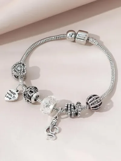 Pulsera de fantasía para dama color plateado con accesorios