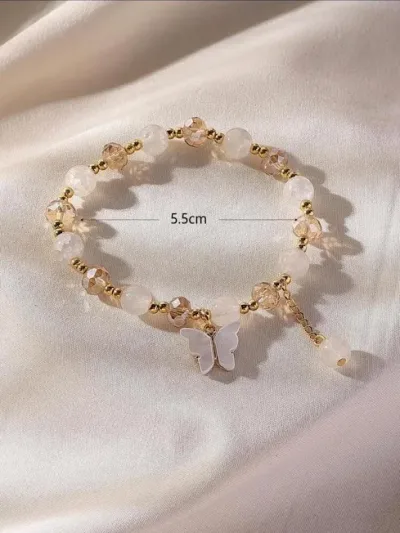 Pulsera de fantasía para dama color blanco y beige con dije de mariposa