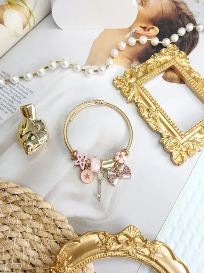Pulsera de fantasía con charms para dama  color dorado