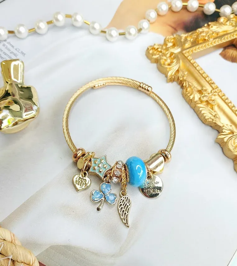 Pulsera de fantasía con charms variados color dorado