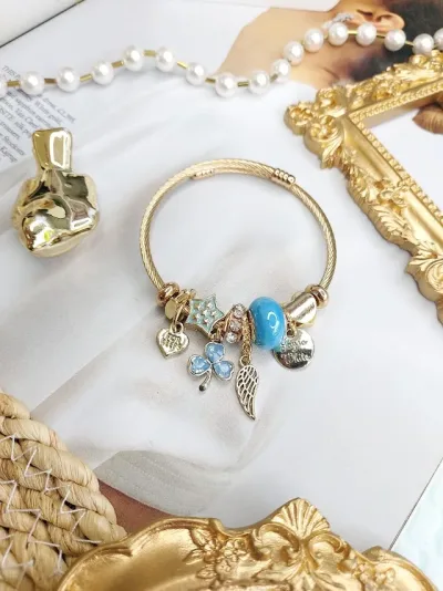 Pulsera de fantasía con charms variados color dorado