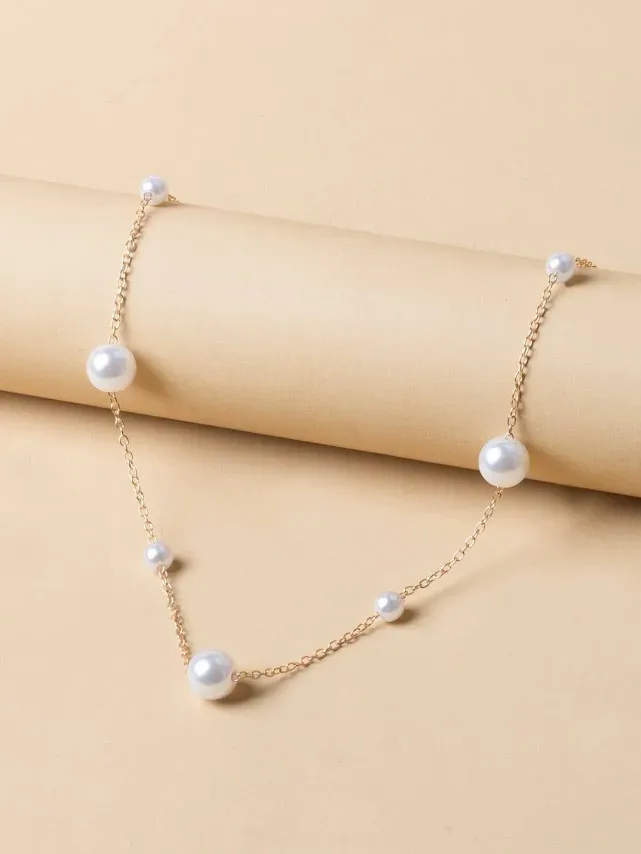 Collar de acero de titano color dorado con perlas blancas