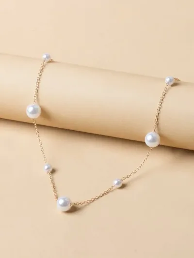 Collar de acero de titano color dorado con perlas blancas