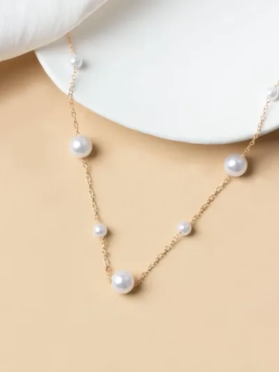 Collar de acero de titano color dorado con perlas blancas